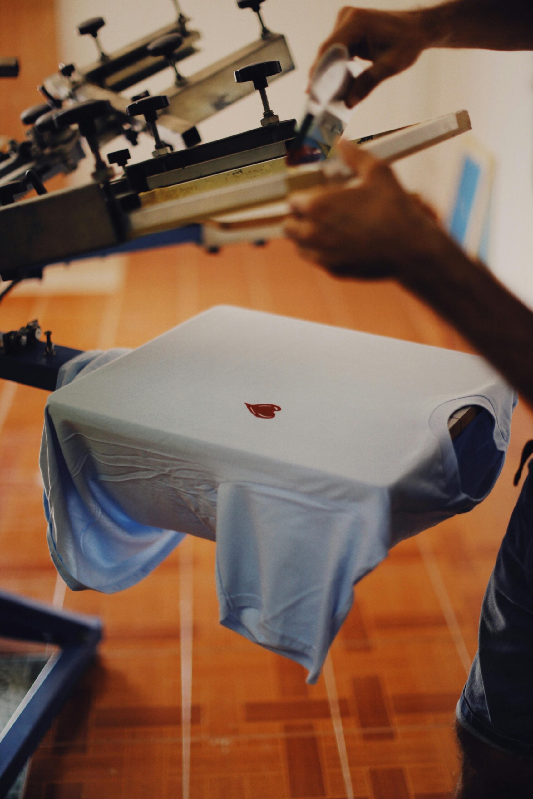 Close-up of a man using a T-shirt printing machine indoors.... CreativefeelLab