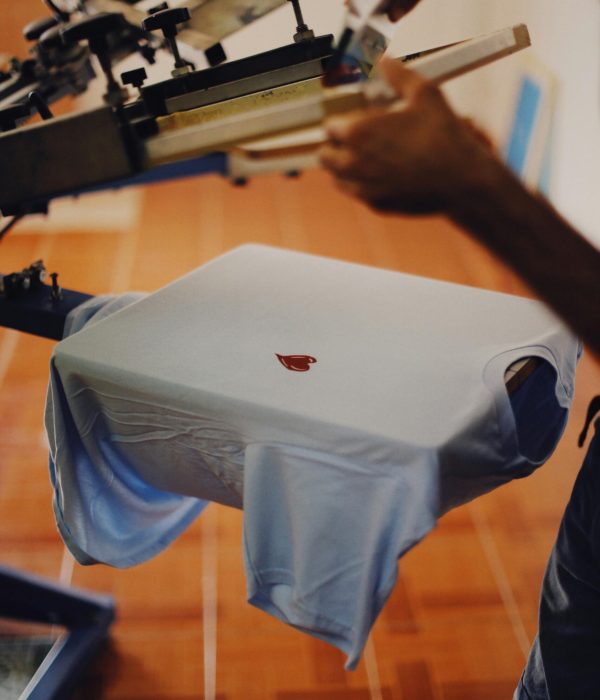 Close-up of a man using a T-shirt printing machine indoors.... CreativefeelLab